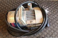 Top side view of the air compressor showing the motor housing and wrapped cable.