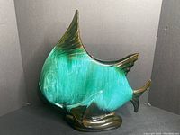 Front-side view of the large green and brown glazed Blue Mountain Pottery angel fish figurine showing its full shape, color, and condition.