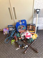 Photo showing entire lot including booster cables, ratchet straps, tire irons, work light, extension cord, and miscellaneous small tools.