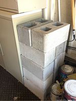 Stack of 10 concrete cinder blocks showing size and condition.