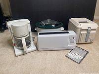 Lot showing all four appliances: Mr. Coffee coffee maker, Rival crockpot, Kitchen Aid toaster, Kenwood deep fryer with manual on floor.