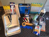 Wide view showing full contents of painting tools and supplies lot including tray, brushes, sandpaper, scrapers, drop cloths, and Varsol container.