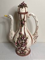 Full view of the vintage Capodimonte swan vase showing body, handle, and lid with floral decorations