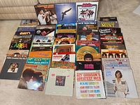 Photo showing entire collection of about 35 vinyl LP records including notable artists like Abba and Tom Jones in colorful album jackets.
