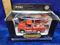 Front view of the boxed Ertl 1955 Chevy Cameo Wrecker die cast truck showing branding, scale, and packaging condition.
