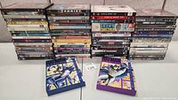 Full view of stacked DVDs showing multiple movie titles and TV series seasons including Batman animated DVDs in front