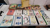 Photo showing multiple vintage children's books including a boxed set of Little House books and various individual books arranged on a flat surface.