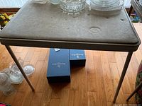 Top surface of vinyl topped card table showing stains and marks.