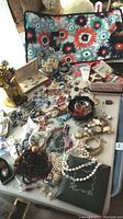 Overhead images of the collection on a table showing assorted costume jewelry, vintage watches, and bath salts.