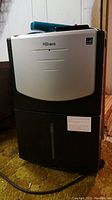 Front view of the Premiere DDR6011R dehumidifier showing black and silver design and water tank area.