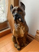 Front view showing the dog sitting upright with detailed facial features and paint.