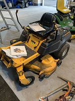 Front side view showing overall mower body, deck, seat and lap bar controls