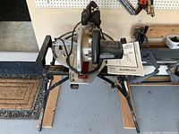 Delta Sidekick 10-inch compound slide saw on folding stand with instruction manual and dust collection bag