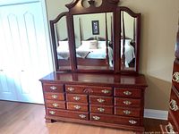 Front view of dresser showing three-panel mirror and nine drawers