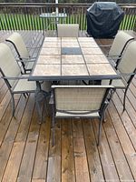 Full view of table and six chairs on wooden deck