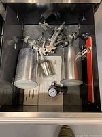 Drawer with air blow gun, two siphon spray guns with metal cups, air regulator and manual