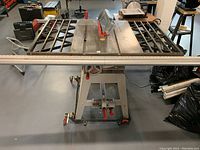 Front view showing tabletop, rip fence, folding stand and extension wings