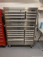 Front view of the two-piece tool chest showing all 18 drawers and caster wheels