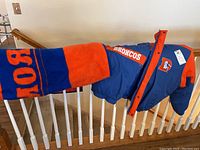 Photo showing Broncos blanket and jacket draped over stair railing