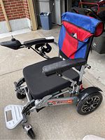 Front-side view of electric wheelchair showing joystick control and seat cushion