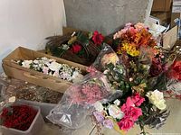 Photo of six boxes containing assorted faux floral arrangements including roses, berries, and autumn leaves.
