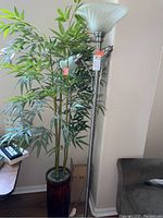 Full view of the brushed nickel floor lamp next to the faux bamboo plant showing relative heights and placement.