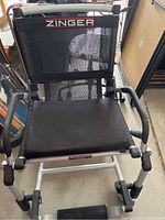 Front view showing black mesh seat and backrest with Zinger branding