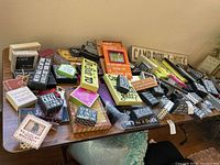 Top view of about 50 assorted wooden wall motto plaques arranged on a table.