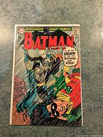 Front cover of Batman comic issue 180 with Batman and Robin in action against a skeleton figure under rain, price marked 12 cents.