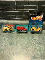 Three sealed Hot Wheels die-cast trucks from the 1980s shown with original packaging