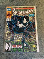Front cover photo showing the full comic book with black suit Spider-Man crouching, surrounded by webbing, and featuring Todd McFarlane signature and date.