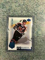 Front of Wayne Gretzky limited edition hockey card in protective sleeve, showing image of Gretzky in All-Star uniform, card number 1423/1999, and blue embossed seal.