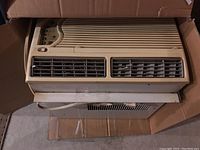 Top view of beige colored window air conditioner unit showing air vents and control panel.