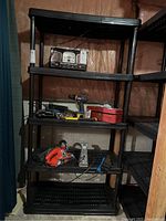 Full view of shelving unit loaded with some tools and items on shelves.