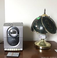 Photo shows the Philips MC138 stereo system beside the decorative touch lamp on a wooden surface.