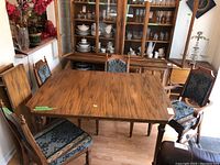 Rectangular wooden dining table with scratches, four matching chairs arranged around it