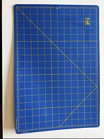 Blue rotary cutting mat with yellow grid lines and measurement markings, marked in inches, includes angled guideline markings.