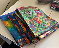 Stack of folded colorful quilting fabric pieces with animal and botanical prints