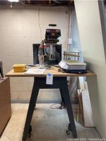 Front view of the Craftsman radial arm saw mounted on wheeled table in basement workspace.