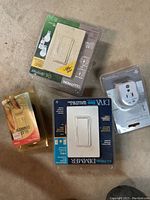 Overview photo showing desk chair mat and various packaged electrical devices including dimmers and surge tap