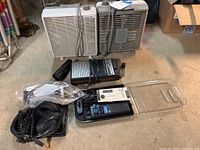 Two box fans, cassette player, 2-way radio, and headset laid out on floor, viewed from above.
