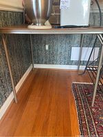 Full side view of the metal folding card table showing metal legs and wood grain faux vinyl surface.