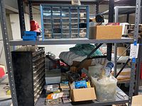 Shelf with two multi-drawer storage boxes containing small fasteners and additional boxes with mixed hardware items.