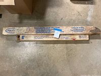 Two original sealed cardboard boxes containing a maple quilting frame with stand and an extension kit.