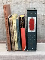 Photo showing spines of six books standing upright including vintage children's and adult books, 'Boat Building with Plywood,' 'Children of Many Lands,' 'Stories Old and New,' 'Stories About Sandy,' and 'My Little Pictionary'.
