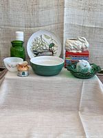 Full view of lot with all glassware, ceramics, and decorative items arranged on fabric background