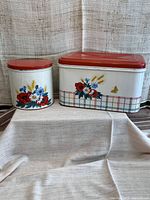 Breadbox and one canister with floral graphics, showing paint condition and colors