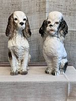 Front view of the vintage handmade ceramic spaniel and poodle dog figurines, showing detailed fur and expressive faces