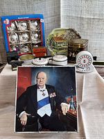 Front view of all items: vintage tins, boxed Christmas baubles, tin toy cookware and plates, miniature metal typewriter and desk.