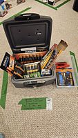Open Sentry safe showing various packages of Duracell batteries and a plastic container with additional batteries and flashlights.